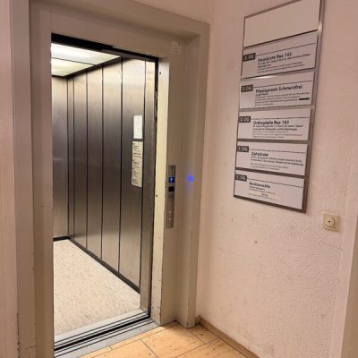 Aufzug im Ärztehaus Rüttenscheider Straße 143 in Essen mit Praxisschild der Physiopraxis Schmerzfrei